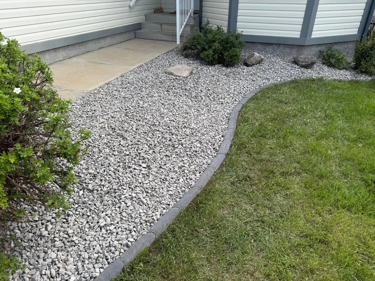 A river-rock foundation bed with trimmed shrubs — kept by us